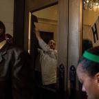 Employees of the Mayo Hotel pull curtains across the inside of the doorway to black out the view into the hotel.
