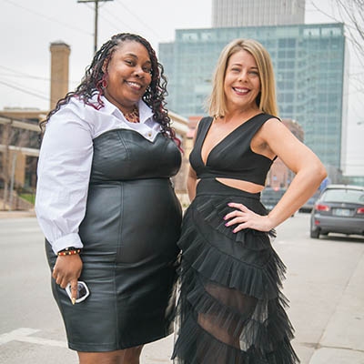 Crystal Ifekoya (left) and Lee Ann Crosby, International Women’s Fashion Show organizers, 
sport runway ready outfits in downtown Tulsa