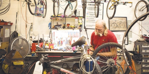 Norman Waters works in “the boneyard” at Tulsa Hub, which distributes road-ready bikes based on community need.