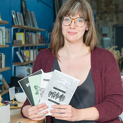 Whitty Books co-founder Victoria Moore holds a stack of zines at her Kendall Whittier bookshop.