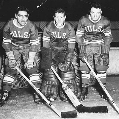 Three Oilers players pose for a promotional photo with goaltender Nelson “Freckle” Little in the center.