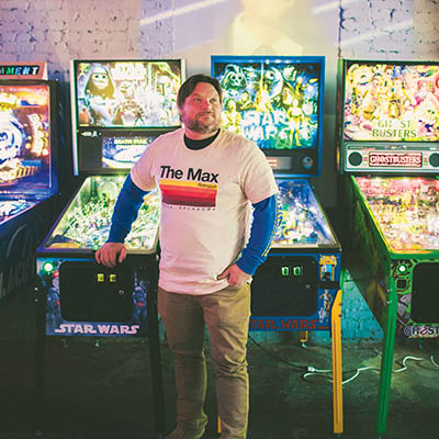 Todd Johnson stands in front of The Max Retropub’s two Star Wars pinball machines