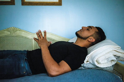 José lays on his bed in prayer. After spending months in ICE detention centers in Texas and Oklahoma he was sponsored by Mary Coleman Woolslayer, who offered him a place to live in her home while he awaits judgement on whether his request for political asylum will be accepted or not.