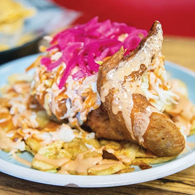 Las Tres Fronteras’ signature dish features perfectly-fried chicken, plantains, pickled cabbage and onions.