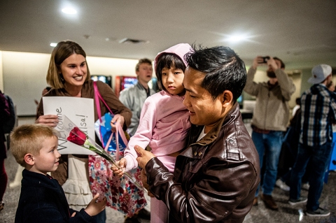 A local child welcomes a new young Tulsan with a rose at Tulsa International Airport on Feb. 8, 2018.