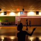 Skaters roll past a mural depicting the original Skateland sign that still stands outside the building. The rink draws up to 500 people from across Tulsa any any given night for skating, games, and concessions.