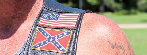 Confederate and American flag patches sewn onto a biker's vest to support the flag at a recent national rally