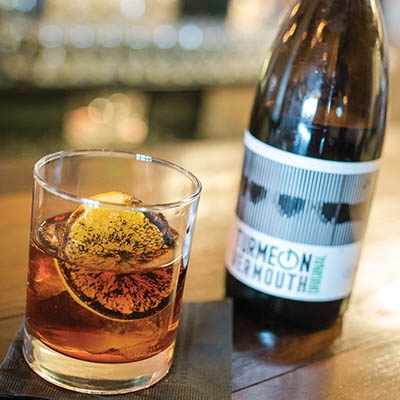 Bird & Bottle’s modified Negroni pays homage to Anthony Bourdain. The thick wedge of orange is torched for garnish. 